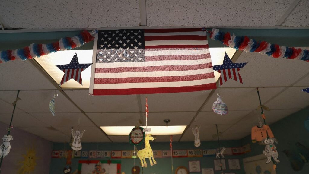 La bandera estadounidense cuelga sobre una guardería mientras los padres participan en una clase de inglés como segundo idioma en un centro de asistencia a inmigrantes en Stamford, Connecticut (foto: AFP)