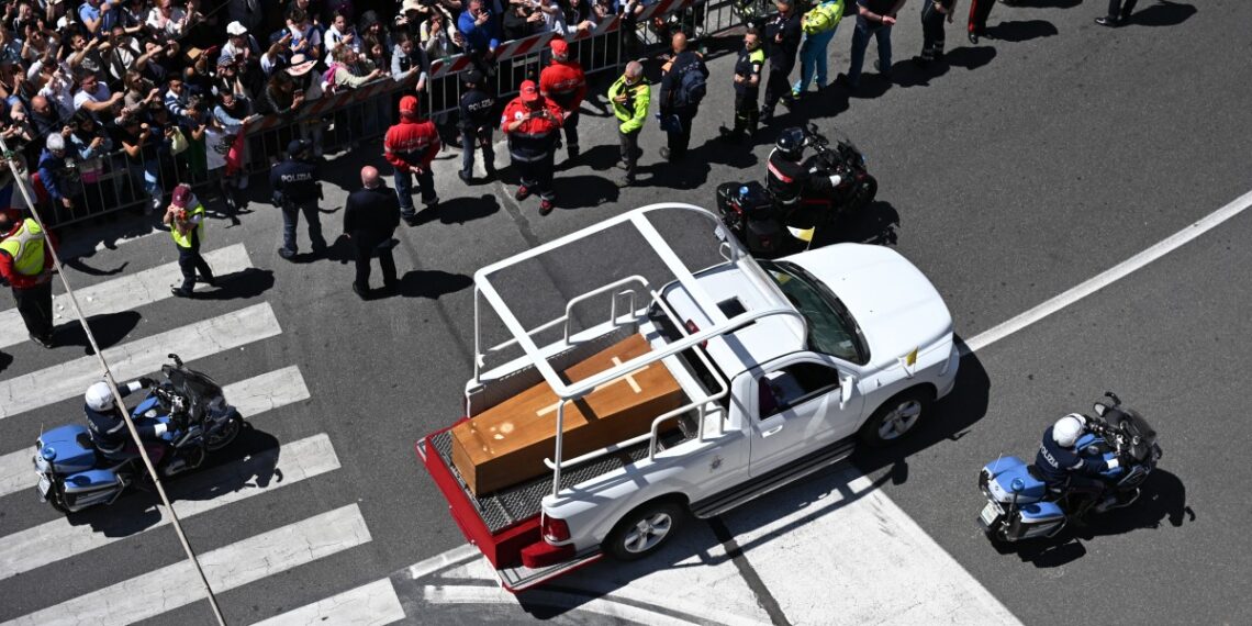 La gente se reúne a lo largo de la carretera mientras el ataúd del difunto Papa Francisco es transportado desde la Basílica de San Pedro a la Basílica de Santa María la Mayor durante la ceremonia fúnebre en Roma el 26 de abril de 2025. (Foto de Piero CRUCIATTI / AFP)