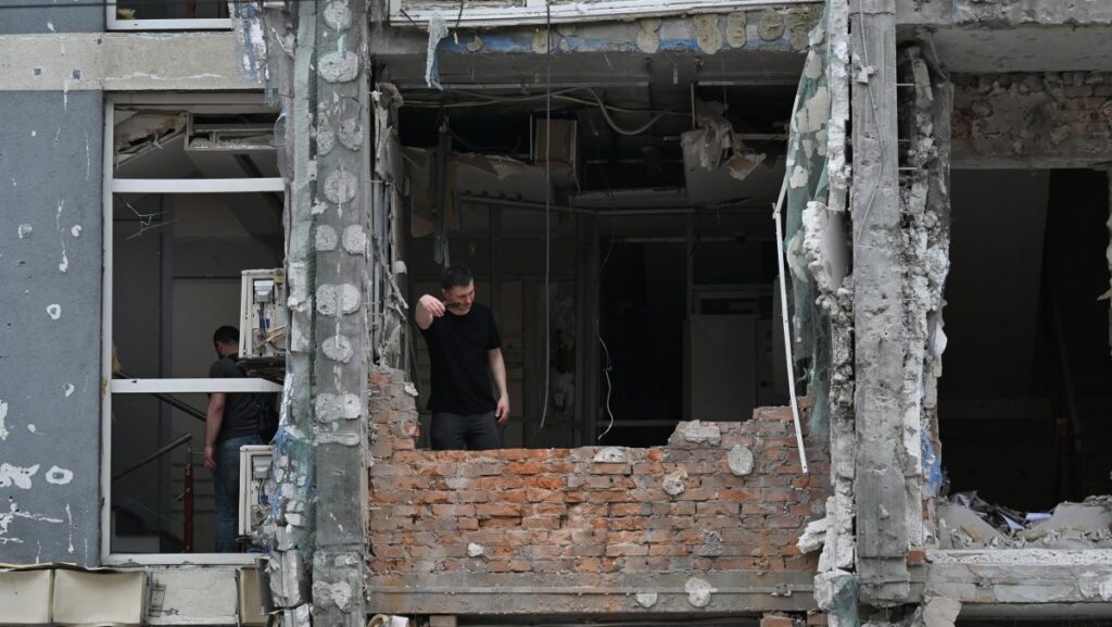 Un residente local se encuentra en un piso dañado de un edificio residencial de varias plantas tras un ataque con drones en Kiev el 25 de mayo de 2025, durante la invasión rusa de Ucrania. Rusia lanzó un número récord de drones contra Ucrania y mató a 12 personas en todo el país, según informaron las autoridades el 25 de mayo, incluso cuando Kiev y Moscú completaron su mayor intercambio de prisioneros desde el inicio de la guerra. (Foto de Sergei SUPINSKY / AFP)