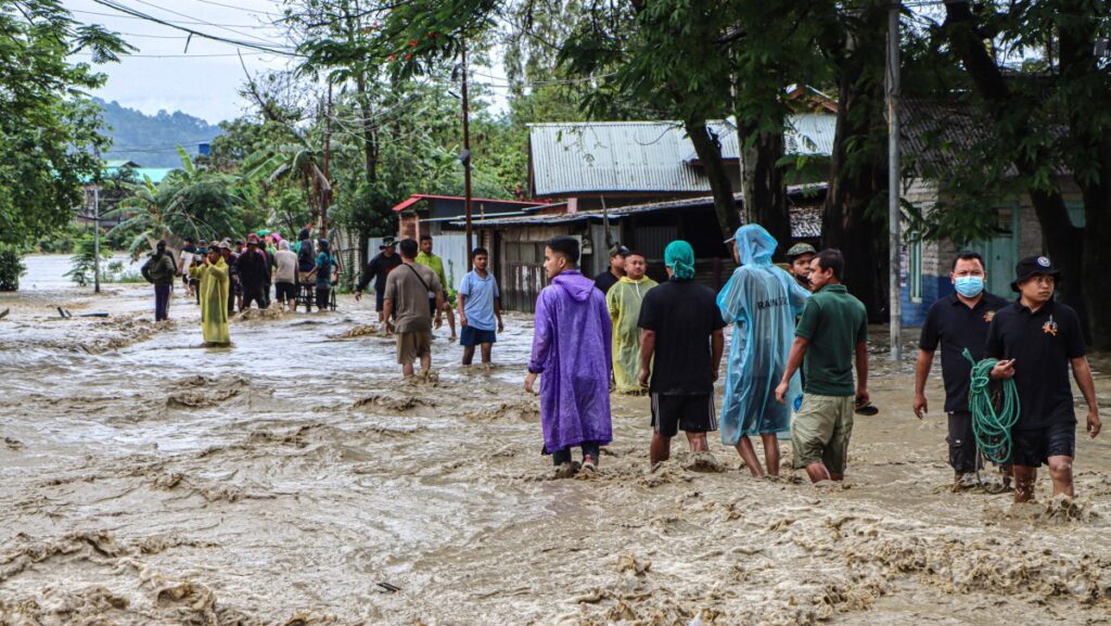 Los residentes caminan por una calle inundada tras las fuertes lluvias en la aldea Khurai Konsam Leikai, en el distrito de Imphal East, en el estado indio de Manipur, el 31 de mayo de 2025. (Foto: AFP)