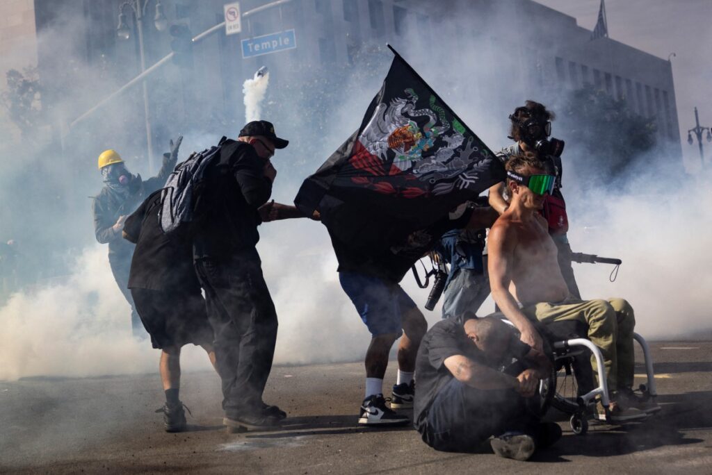 Un manifestante lanza una bomba de gas lacrimógeno contra las fuerzas del orden durante los enfrentamientos que estallaron después de que las autoridades declararan ilegal una reunión durante la protesta "Sin Reyes" contra la administración Trump en Los Ángeles el 14 de junio de 2025, el mismo día del desfile militar de Trump en Washington, D.C. (Foto de ETIENNE LAURENT / AFP)