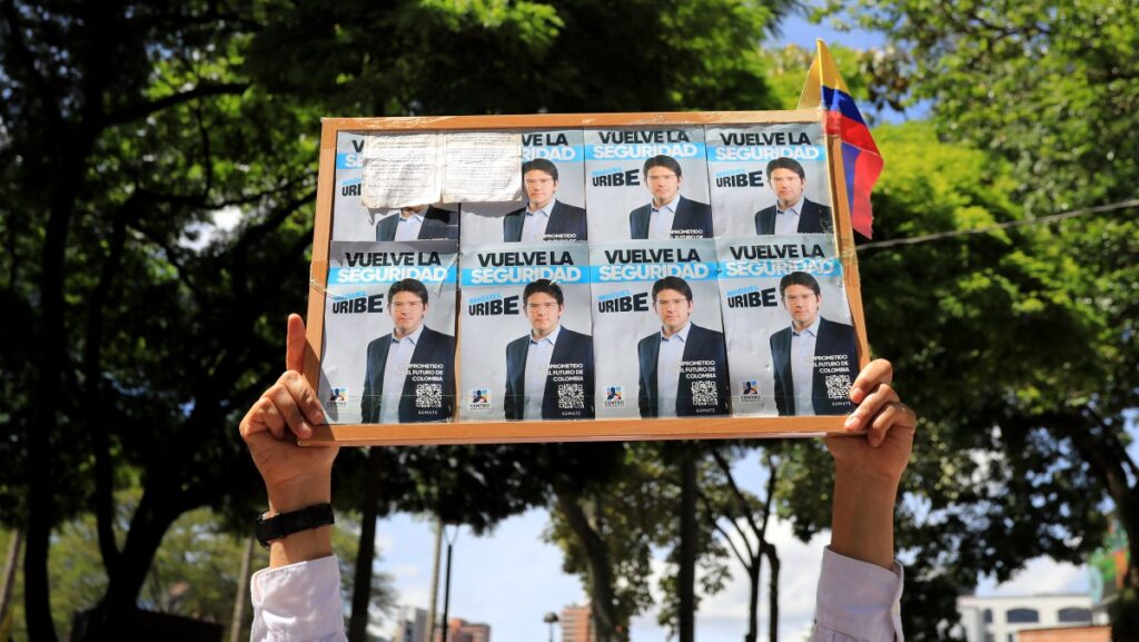 Un hombre sostiene un cartel con propaganda del candidato presidencial Miguel Uribe durante una protesta contra la violencia y a favor de la paz en Medellín, Colombia, el 8 de junio de 2025, un día después del ataque a Uribe. Un destacado candidato presidencial colombiano de derecha, que recibió un disparo durante un acto de campaña en Bogotá, fue sometido con éxito a una primera cirugía, según informó el alcalde de la ciudad el domingo. (Foto de JAIME SALDARRIAGA / AFP)